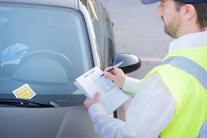 Carro sendo multado por estar estacionado em local proibido