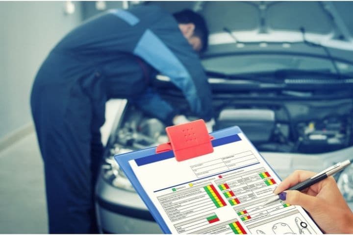 mecânico realizando manutenção preventiva em carro e conferindo checklist