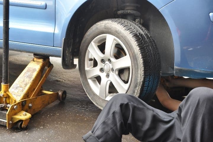 mecânico realizando manutenção em carro quebrado